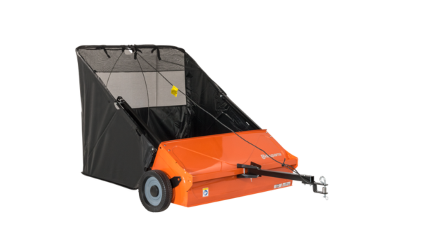 Husqvarna veegmachine gemonteerd op frontmaaier, toont roterende borstel in actie bij het vegen van bladeren op een tuinpad.