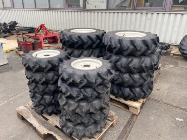 Zgan landbouwbanden voor Iseki/Kubota: Alliance 9.5‑16 voor en Bridgestone 6‑12 achter.